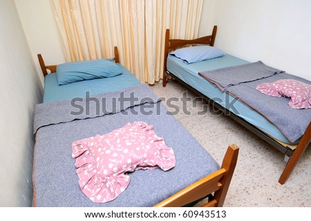 Twin beds in simple motel room. Suitable for concepts such as budget travel, tourism, vacation and holiday, and relaxation.