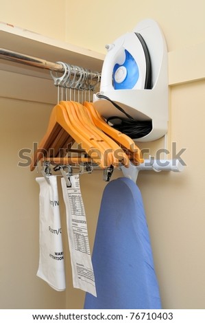 Interior of clothes rack with hangers and iron equipment.