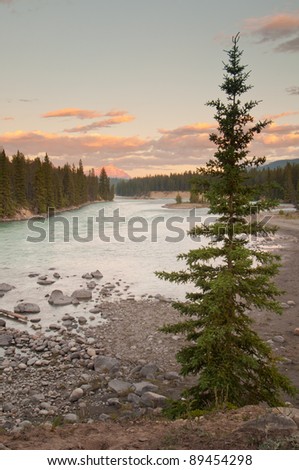 Landscape view of river in the wilderness with beautiful sun rays on distant mountain.