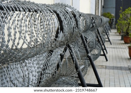 a row of barbed wire fences lined up at a location, serving as security measures and deterrents against potential disturbances Foto stock © 