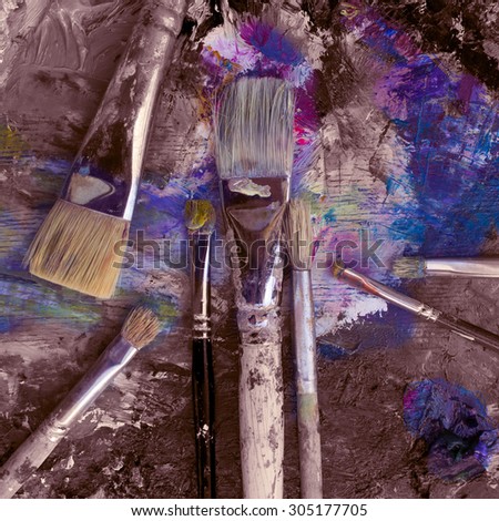 Art brushes on the palette with a palette knife