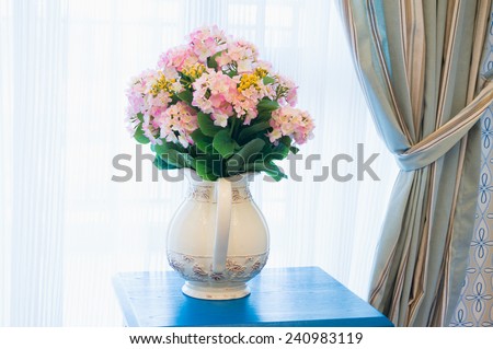 flower with vase on side table beside the window