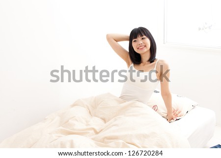 attractive asian woman awaking on  the bed