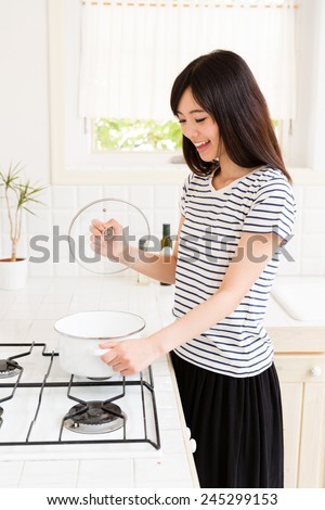 young asian woman cooking in the kitchen