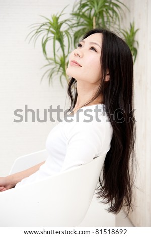 beautiful asian woman sitting on the chair in the room