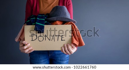 Donation Concept. Woman holding a Donate Box with full of Clothes Foto d'archivio © 