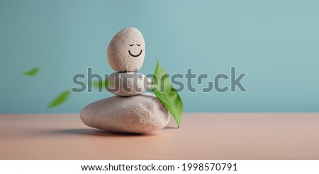 Enjoying Life, Harmony and Positive Mind Concept. Stack of Stable Pebble Stone with Smiling Face Cartoon and Leaf. Serene, Balancing Body, Mind, Soul and Spirit. Mental Health Practice