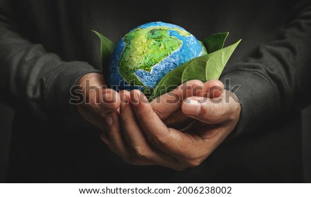 World Earth Day Concept. Green Energy, ESG, Environmental, social and corporate governance. Renewable and Sustainable Resources. Environmental and Ecology Care. Hand Embracing Green Leaf and Globe Stock foto © 