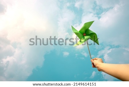 ESG and Clean Energy Concept. Hand Raise up a Wind Turbine Paper into the Sky. Decrease Carbon and Produce a Green Power. World Earth Day, Sustainable Resources, Environmental Care Сток-фото © 