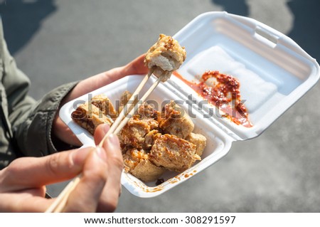 Eating fried stinky tofu on the street, China