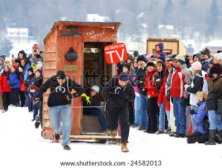 LAKE GEORGE, NY - February 7, 2009: An outhouse race team runs their hardest to win at the February 7 , 2009 Lake George Winter Carnival.