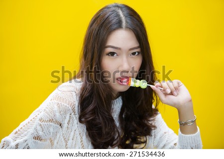 Portrait of Asian Cute young woman eating jelly candies and look camera