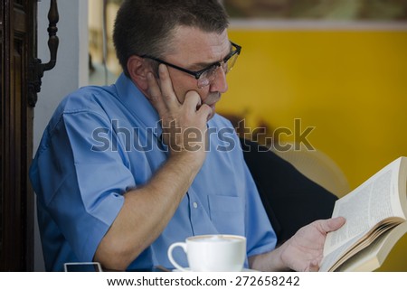 Man seriously Reading a book in cafe