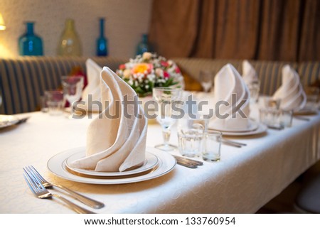 A very nicely decorated wedding table with plates and serviettes.