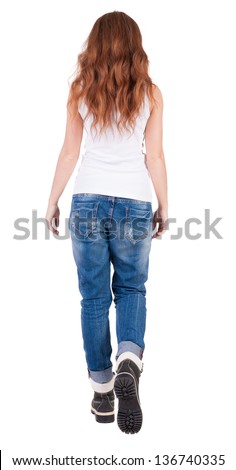 back view walking  leggy woman. beautiful redhead girl in motion. backside view person. Rear view people collection. Isolated over white background. trendy teen girl goes in mountain boots and jeans