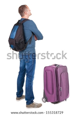 Back view man with photographic backpack looking up. Rear view people collection.  backside view of person.  Isolated over white background. guy in the green t-shirt stands with a suitcase on wheels