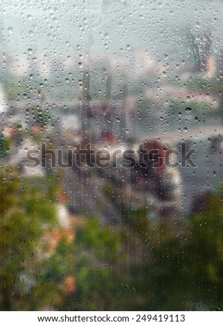 Autumn, rainy city through a window with raindrops. autumnal mood.