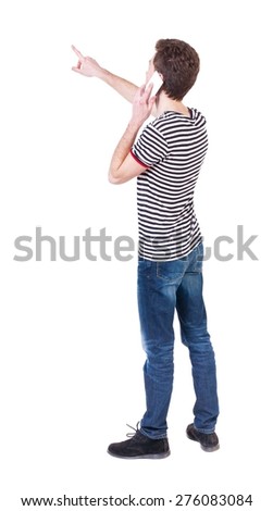 Back view of  pointing young men talking on cell phone. Young guy  gesture. Rear view people collection.    Isolated over white background. Curly guy on the phone tells what he saw.