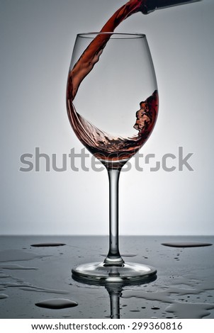 jet filling a glass of wine , studio product photography .