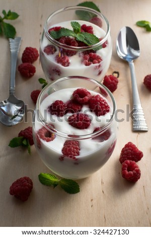 homemade yogurt with raspberry and mint leaves in glass, healthy and tasty diet, for weight losing, serving food for two persons