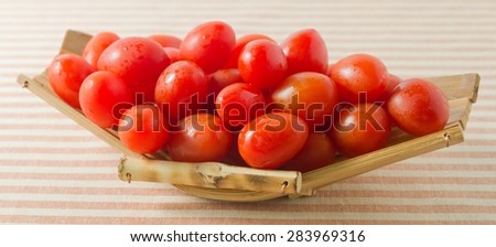 Vegetable, Fresh Ripe Red Grape Tomatoes or Cherry Tomatoes on A Small Bamboo Boat.