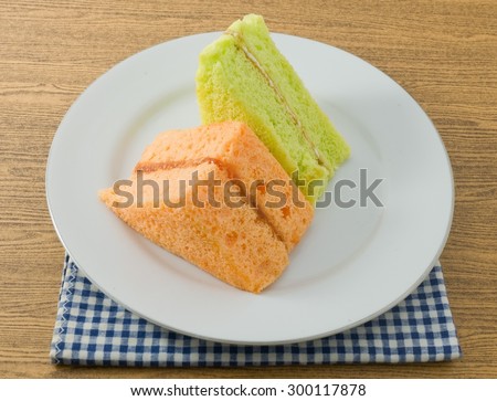 Snack and Dessert, Pandan and Orange Chiffon Cake Made With Butter, Eggs, Sugar, Flour, Baking Powder and Flavorings on A White Dish.