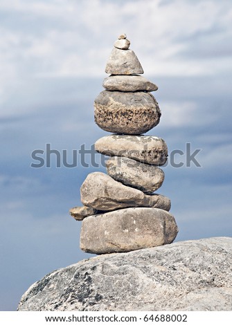 A stack of rocks sitting on a larger rock on a michigan shoreline