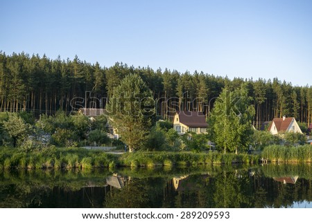 River house with reflections and blue sky near the forest
