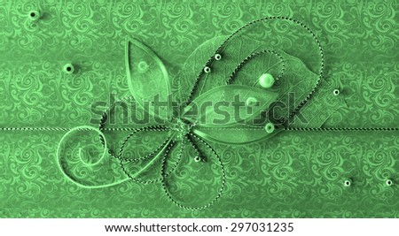Green handmade greeting decoration with shiny beads, embroidery, silver thread in form of flower and butterfly on background of vintage fabric