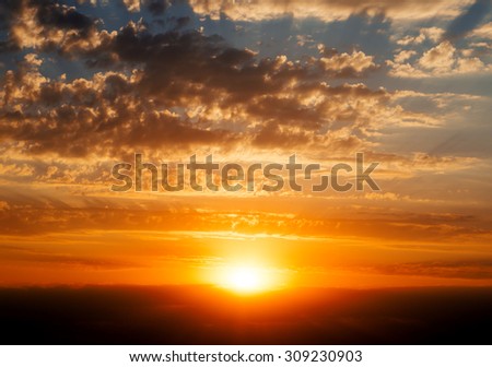 Beautiful blue cloudy sky with golden red sunset and rays of light