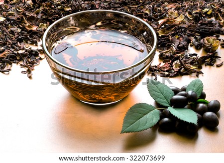 Still life cup of black tea with mint leaves on dried karkade tea background yellow filtered