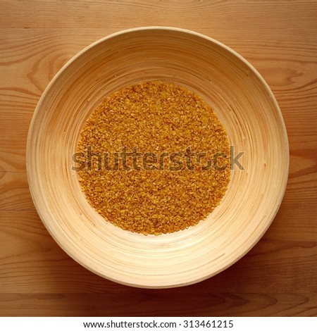 Bamboo Bowl with Bulgur on Wood Background