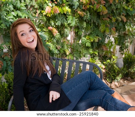 Happy teen girl sitting in an outdoor dining area on a sunny day