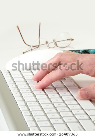 Computer keyboard and mouse with typing hand, eyeglasses, and pen