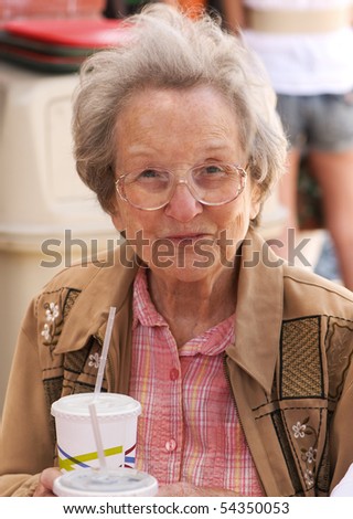 Elderly lady of 88 years having lunch outdoors at a taco stand