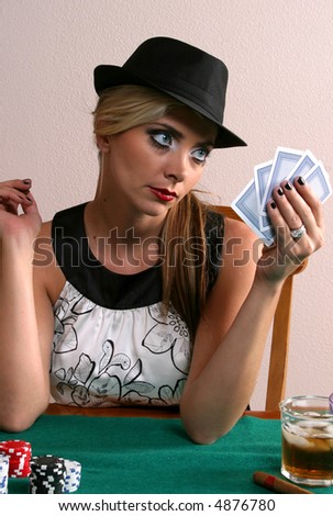 Beautiful woman with cards in hand and chips on table.