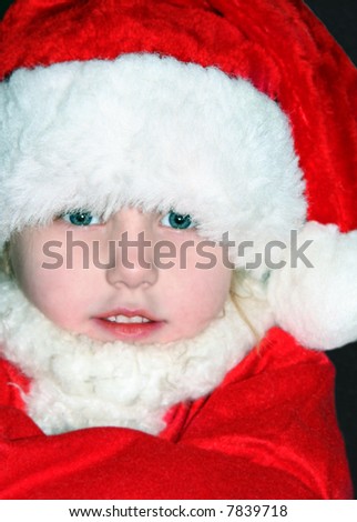 Cute little girl bundled up in a santa suit.