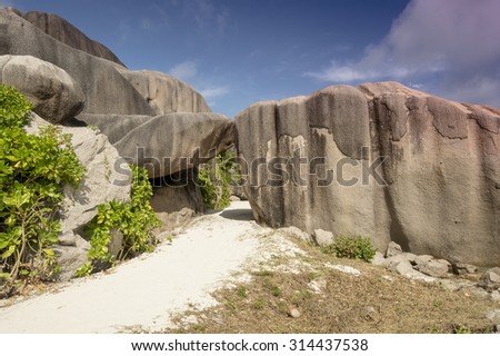 Path between big granite boulders in La Digue island Seychelles. This pathway goes to Anse Source dÃÂ¢Ã?Ã?Argent beach. Vacation background.