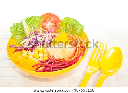 Fresh mixed vegetables salad in yellow bowl.