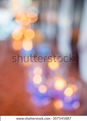 Colorful of bokeh background. Abstract blurred of Light candles from people are worship Buddha in the temple.