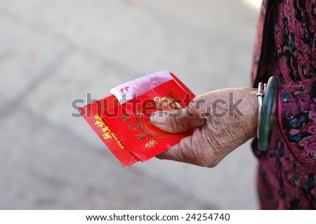 China red packets in an old woman hand, in Chinese new year, the old man will put some money in the red packets, and give it to young boy & girl, to wish them happiness in the new year.