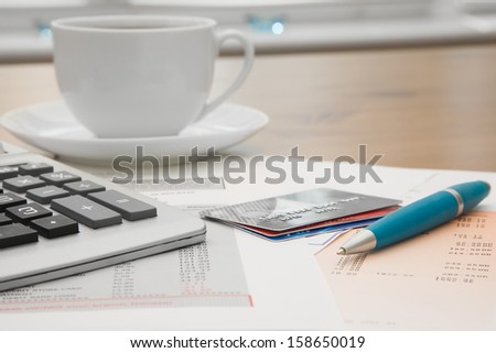 Close up of a credit cards,credit card statements and calculator with a cup of coffee in the background