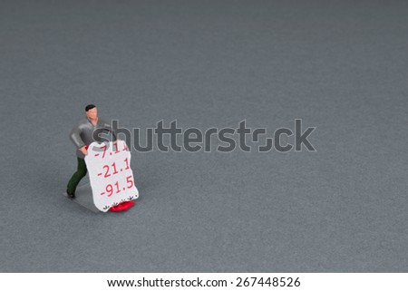 plastic workman figurine with a torn section of bank statement on a trolley.
