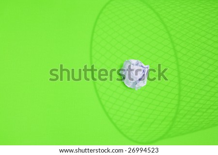 white paper ball over a waste basket shadow
