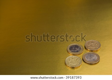 British One Pound And One Euro Coins on a Gold Background