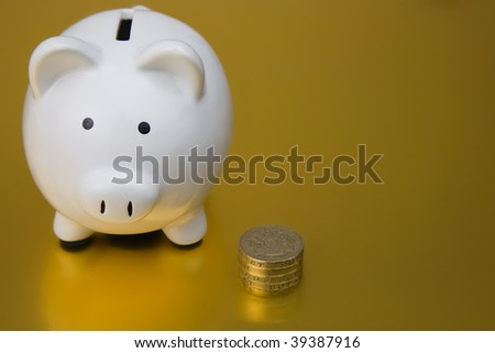 White Piggy Bank and British One Pound Coins on a Gold Background