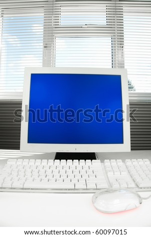 Computer with blank blue screen monitor for copy space