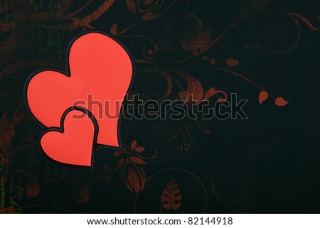 Two Red Love hearts joined together with a black and red flower wallpaper background