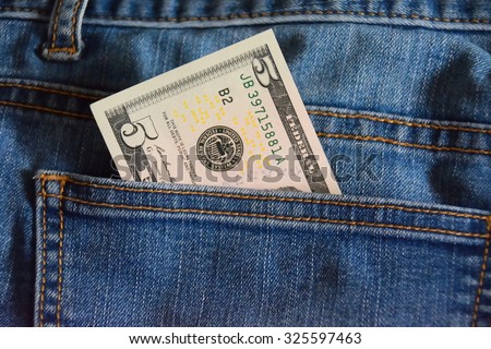 note of five dollars in the jeans pocket, closeup