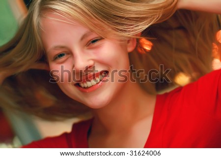 Portrait of the beautiful happy young girl of the blonde with an open smile